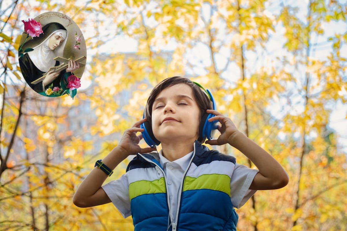 Młody chłopiec w lesie z słuchawkami na uszach słuchający muzyki